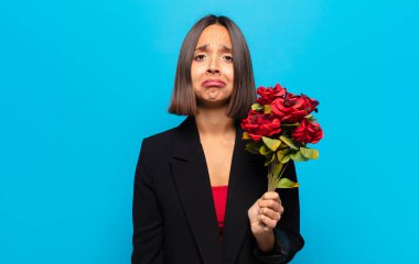 Genç ve güzel bir kadın elinde bir buket gül tutuyor.