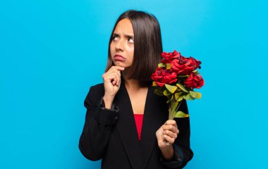 Genç ve güzel bir kadın elinde bir buket gül tutuyor.