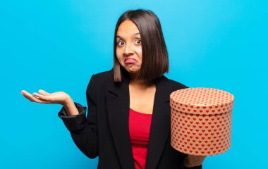 Genç ve güzel bir kadın elinde bir hediye kutusu tutuyor.