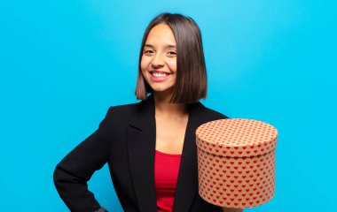 Genç ve güzel bir kadın elinde bir hediye kutusu tutuyor.