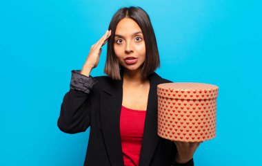 Genç ve güzel bir kadın elinde bir hediye kutusu tutuyor.