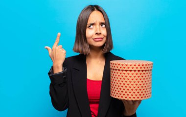 Genç ve güzel bir kadın elinde bir hediye kutusu tutuyor.