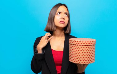 Genç ve güzel bir kadın elinde bir hediye kutusu tutuyor.