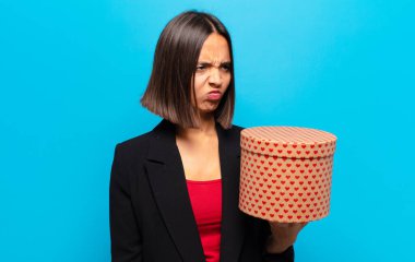 Genç ve güzel bir kadın elinde bir hediye kutusu tutuyor.