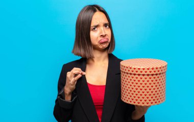 Genç ve güzel bir kadın elinde bir hediye kutusu tutuyor.