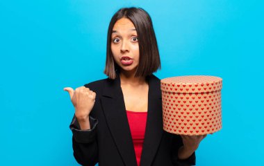 Genç ve güzel bir kadın elinde bir hediye kutusu tutuyor.