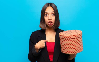 Genç ve güzel bir kadın elinde bir hediye kutusu tutuyor.