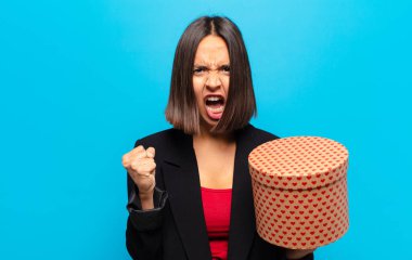 Genç ve güzel bir kadın elinde bir hediye kutusu tutuyor.