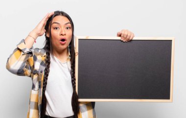 İspanyol kadın mutlu, şaşkın ve şaşırmış görünüyor, gülümsüyor ve inanılmaz ve inanılmaz iyi haberleri fark ediyor.