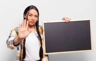 İspanyol kadın ciddi, sert, hoşnutsuz ve kızgın görünüyor. Avuç içinin açık olması jesti durduruyor.