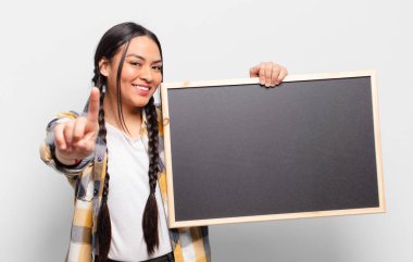 İspanyol kadın gururla gülümsüyor ve gururla bir numaralı pozunu veriyor, kendini lider gibi hissediyor.