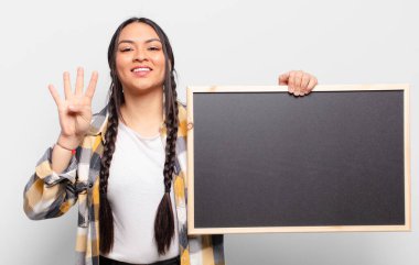 İspanyol kadın gülümsüyor ve arkadaş canlısı görünüyor. Elleri önde, geriye doğru sayıyor.