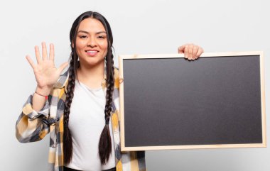 İspanyol kadın gülümsüyor ve arkadaş canlısı görünüyor, 5 ya da 5 numarayı gösteriyor, elleri önde, geri sayıyor.