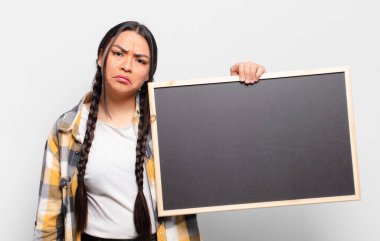 Hispanik kadın üzgün ve mızmızlanıyor, mutsuz bir bakışla, negatif ve hayal kırıklığına uğramış bir tavırla ağlıyor.