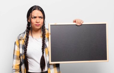 Hispanik kadın üzgün, üzgün ya da kızgın ve olumsuz bir tavır takınıyor, anlaşmazlık içinde kaşlarını çatıyor.