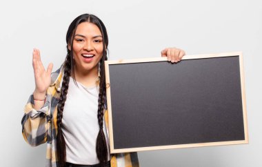 İspanyol kadın kendini mutlu, şaşırmış ve neşeli hissediyor. Pozitif bir tavırla gülümsüyor. Bir çözüm ya da fikir buluyor.