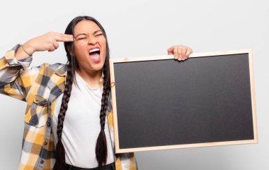 İspanyol kadın mutsuz ve stresli görünüyor, intihar jesti elle silah işareti yapıyor, kafasını işaret ediyor.