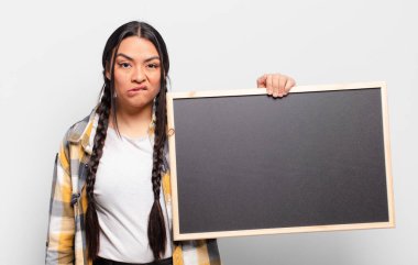 İspanyol kadın şaşkın ve şaşkın görünüyor. Sinirli bir hareketle dudağını ısırıyor. Sorunun cevabını bilmiyor.