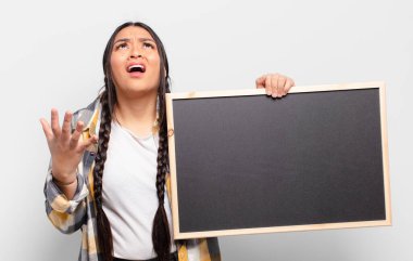 İspanyol kadın umutsuz ve sinirli görünüyor, stresli, mutsuz ve sinirli, bağırıyor ve çığlık atıyor.