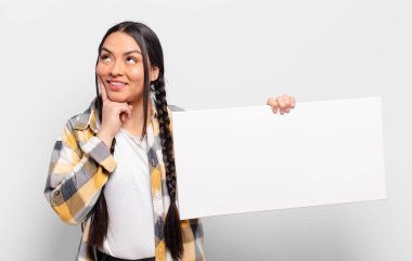 İspanyol kadın mutlu bir şekilde gülümsüyor ve hayal kuruyor ya da şüphe ediyor.