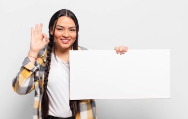 İspanyol kadın kendini mutlu, rahat ve tatmin olmuş hissediyor. Onayını iyi bir hareketle gösteriyor. Gülümsüyor.