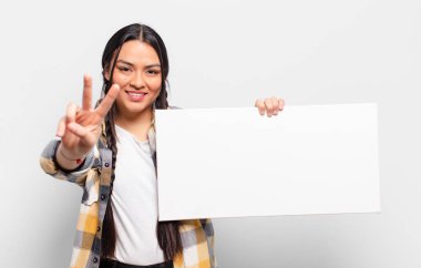 İspanyol kadın gülümsüyor ve mutlu görünüyor, kaygısız ve pozitif, zafer ya da barış simgesi.