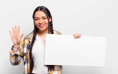 İspanyol kadın gülümsüyor ve arkadaş canlısı görünüyor, 5 ya da 5 numarayı gösteriyor, elleri önde, geri sayıyor.