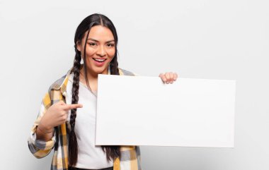 İspanyol kadın heyecanlı ve şaşırmış görünüyor. Yana ve yukarı doğru uzayı gösteriyor.