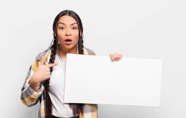 İspanyol kadın şok olmuş ve şaşırmış görünüyor, ağzı açık, kendini işaret ediyor.