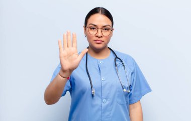 İspanyol kadın ciddi, sert, hoşnutsuz ve kızgın görünüyor. Avuç içinin açık olması jesti durduruyor.