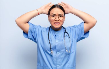 İspanyol kadın kendini stresli, endişeli, endişeli ya da korkmuş hissediyor. Elleri başının üstünde, hatayla panikliyor.