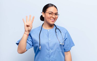 İspanyol kadın gülümsüyor ve arkadaş canlısı görünüyor. Elleri önde, geriye doğru sayıyor.