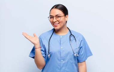 İspanyol kadın mutlu bir şekilde gülümsüyor, mutlu hissediyor ve fotokopi uzayında bir konsept gösteriyor.