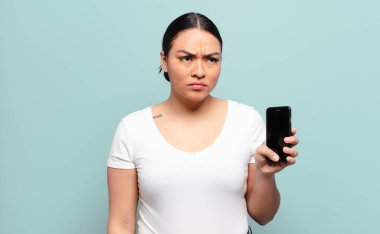 Hispanik kadın üzgün, üzgün ya da kızgın ve olumsuz bir tavır takınıyor, anlaşmazlık içinde kaşlarını çatıyor.