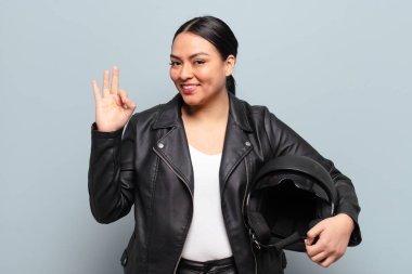 İspanyol kadın kendini mutlu, rahat ve tatmin olmuş hissediyor. Onayını iyi bir hareketle gösteriyor. Gülümsüyor.