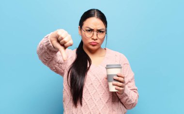 Hispanik kadın kızgın, sinirli, hayal kırıklığına uğramış ya da hoşnutsuz, ciddi bir bakışla başparmaklarını göstermiyor.