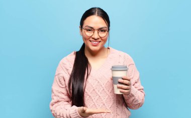 İspanyol kadın mutlu bir şekilde gülümsüyor, mutlu hissediyor ve fotokopi uzayında bir konsept gösteriyor.