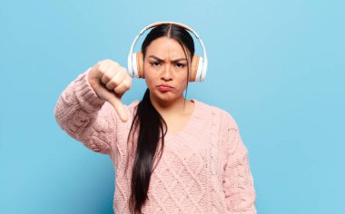 Hispanik kadın kızgın, sinirli, hayal kırıklığına uğramış ya da hoşnutsuz, ciddi bir bakışla başparmaklarını göstermiyor.