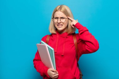 Sarışın kadın şaşkın ve şaşkın hissediyor. Deli, deli ya da aklını kaçırmış olduğunu gösteriyor.