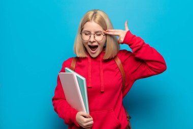 Sarışın kadın mutsuz ve stresli görünüyor, intihar jesti elle silah işareti yapıyor, kafasını işaret ediyor.