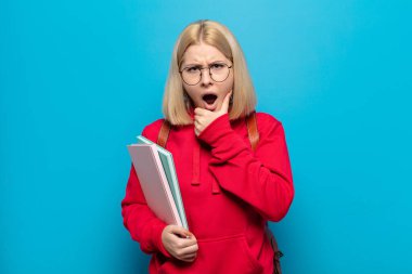 Sarışın, ağzı ve gözleri açık ve eli çenesinde olan bir kadın. Hoş olmayan bir şok geçiriyor. Ne diyor?