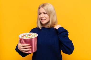 sarışın kadın stresli, endişeli, yorgun ve hayal kırıklığına uğramış, gömleğini çekiştiren, sıkıntılı görünen