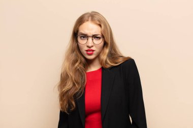 blonde woman feeling puzzled and confused, with a dumb, stunned expression looking at something unexpected