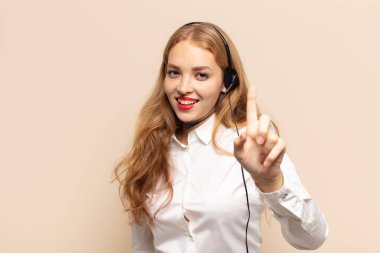 Sarışın kadın gururla gülümsüyor ve gururla bir numaralı pozunu veriyor, kendini lider gibi hissediyor.