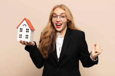 Sarışın kadın şaşkın, heyecanlı ve mutlu, gülüyor ve başarıyı kutluyor,!