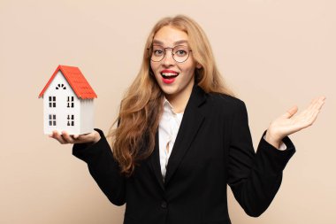 Sarışın kadın mutlu, heyecanlı, şaşırmış ya da şaşırmış hissediyor. İnanılmaz bir şeye gülümsüyor ve şaşırıyor.