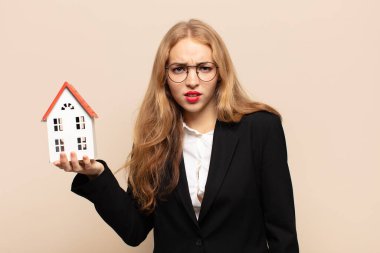 blonde woman feeling puzzled and confused, with a dumb, stunned expression looking at something unexpected