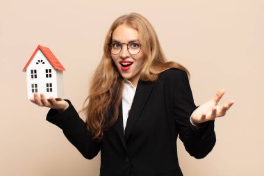 Sarışın kadın şok olmuş ve şaşırmış, endişeli ve paniklemiş, stresli ve dehşete düşmüş bir şekilde bakıyor.