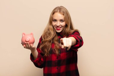 Tatmin olmuş, kendine güvenen, dostça gülümseyen ve seni seçen sarışın bir kadın.