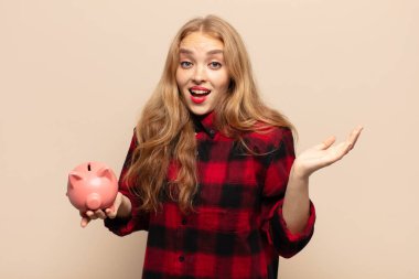 Sarışın kadın mutlu, heyecanlı, şaşırmış ya da şaşırmış hissediyor. İnanılmaz bir şeye gülümsüyor ve şaşırıyor.